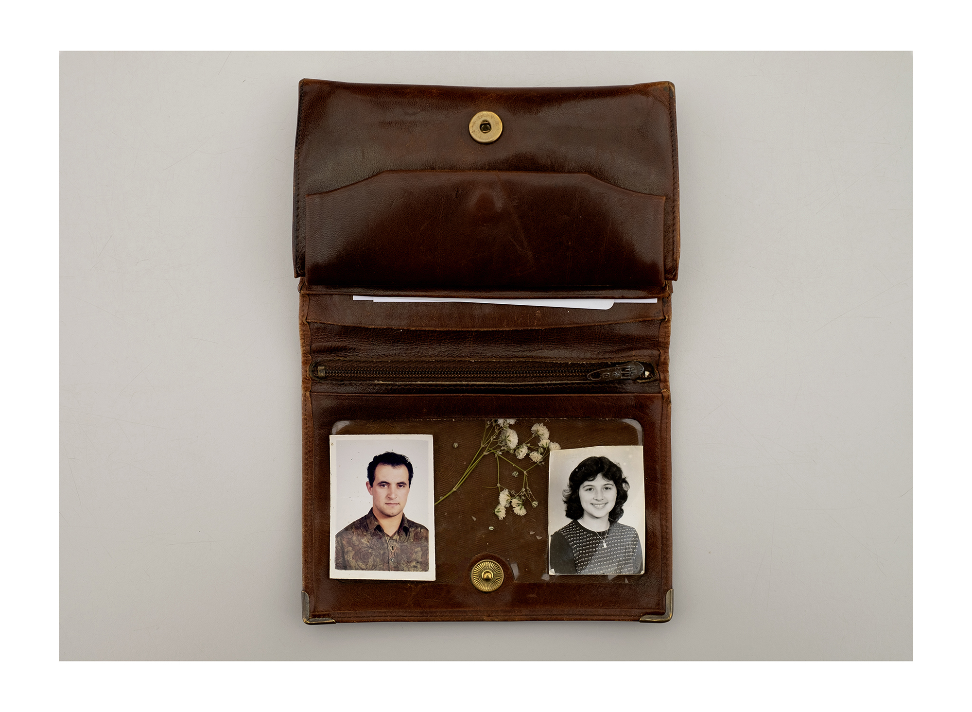 Carteira com três fotografias antigas e um cartão bancário.