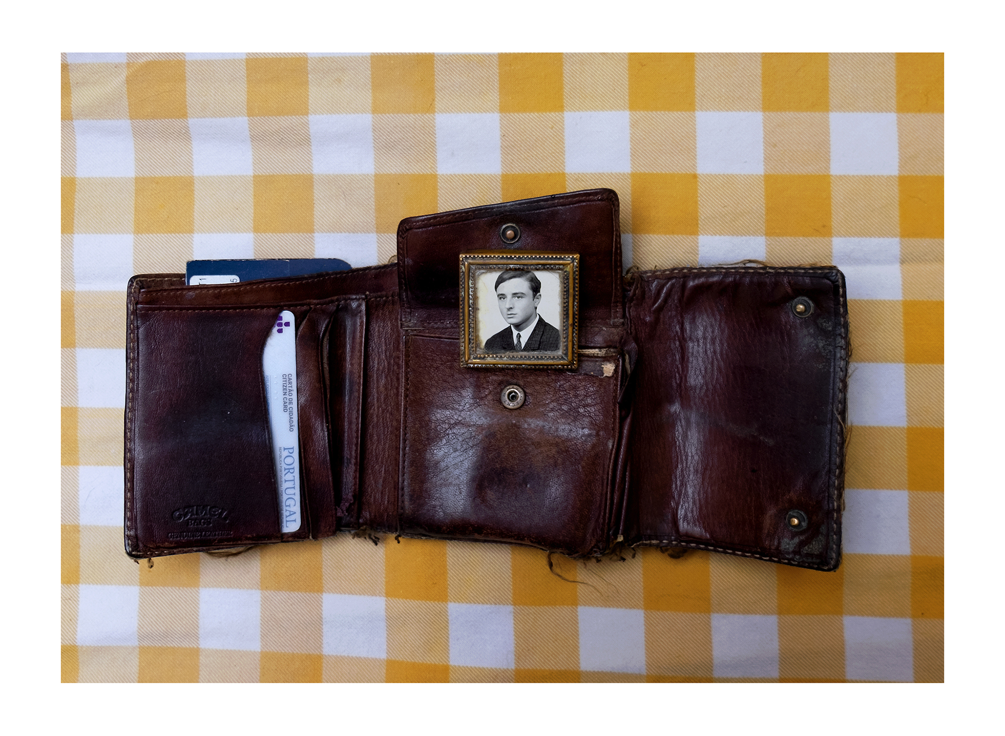 Carteira preta com fotografias de homem e mulher idosos e três crianças.