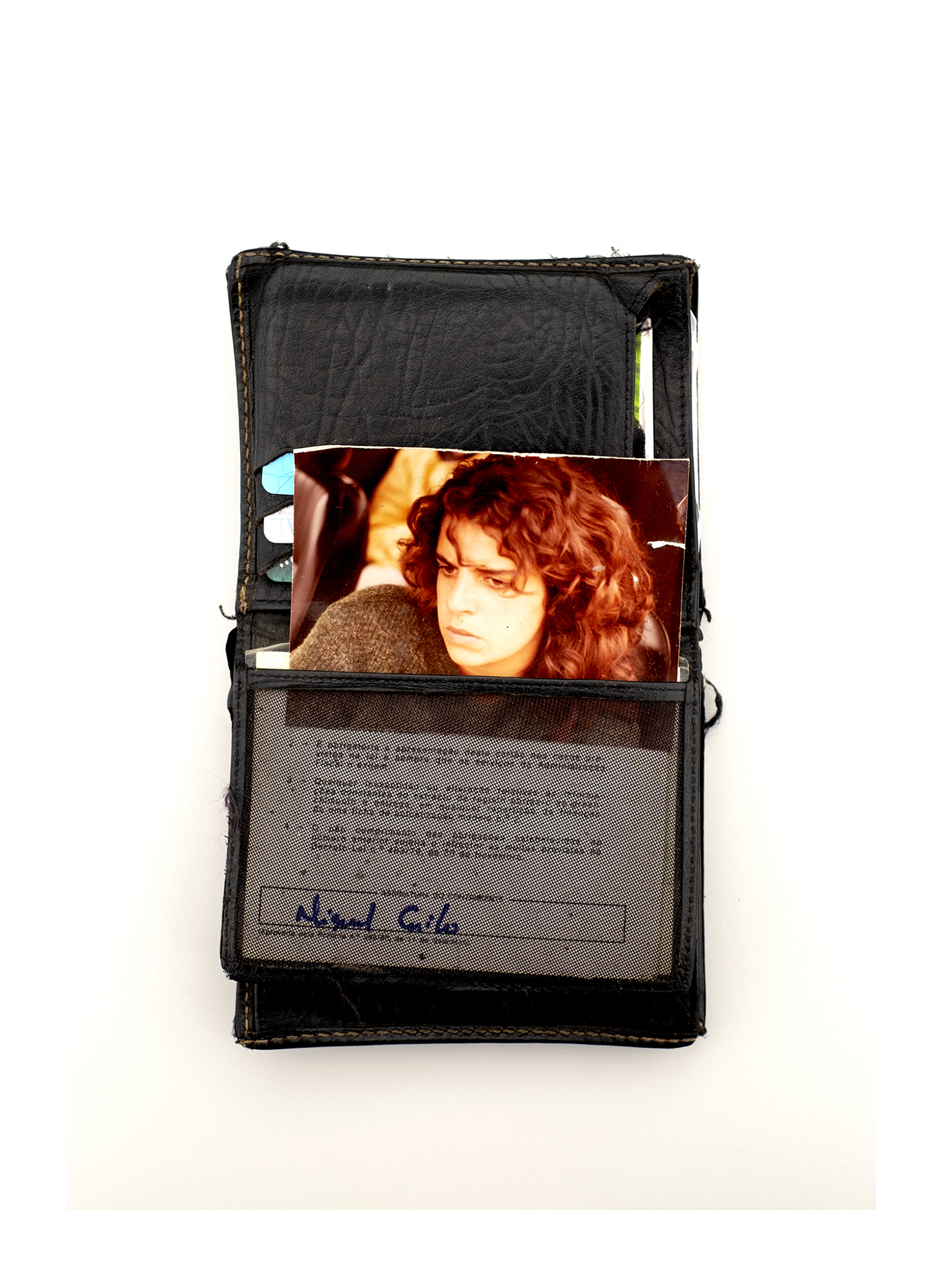 Carteira castanha com uma fotografia de um casamento e duas moedas.