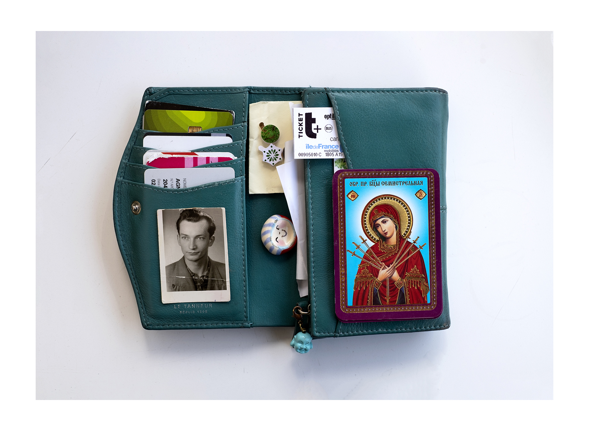 Carteira vermelha com duas fotografias de uma criança e cartões coloridos.